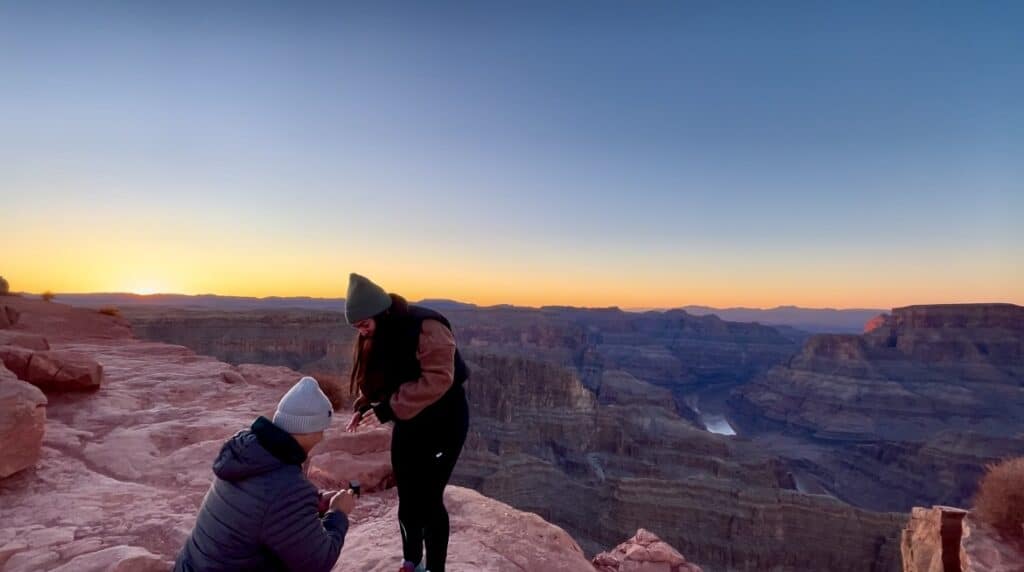 Boyfriend proposing to girlfriend at the grand canyon with a gorgeous sunset in the back. 