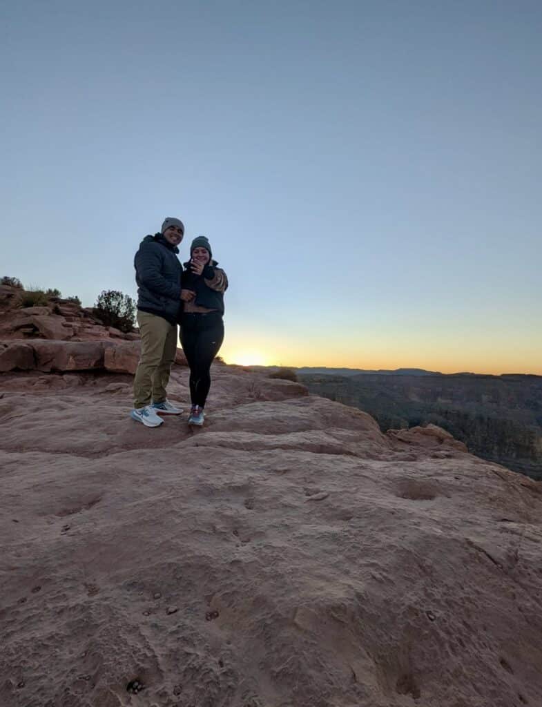 Couple posing for their picture at the Grand Canyon. 