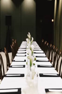 dinner table set , white tablecloth, black napkins, white menu card, white floral centerpieces with candles, Orlando, FL