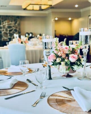 close up of a dinner reception table, gold chargers, white napkins, white tablecloths, pink floral centerpiece, Orlando, FL