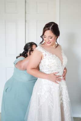 bridesmaid helping the bride with her dress, Orlando, FL