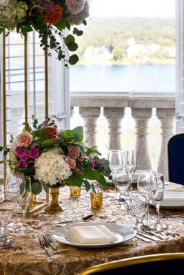 dinner table set with glassware, plates, flatware, floral centerpiece, view of the water, Orlando, FL