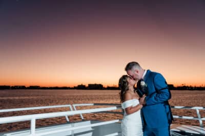 bride and groom on a boat, kissing and dancing, sunset, Orlando, FL