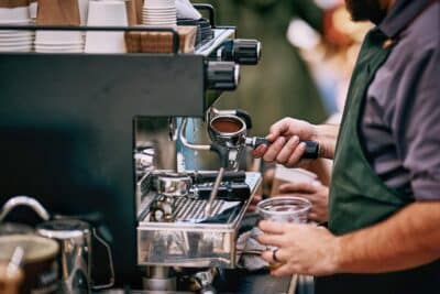 Bautista using the coffee machines to make beverages for guests, Piccolo Coffee Co, Orlando, FL