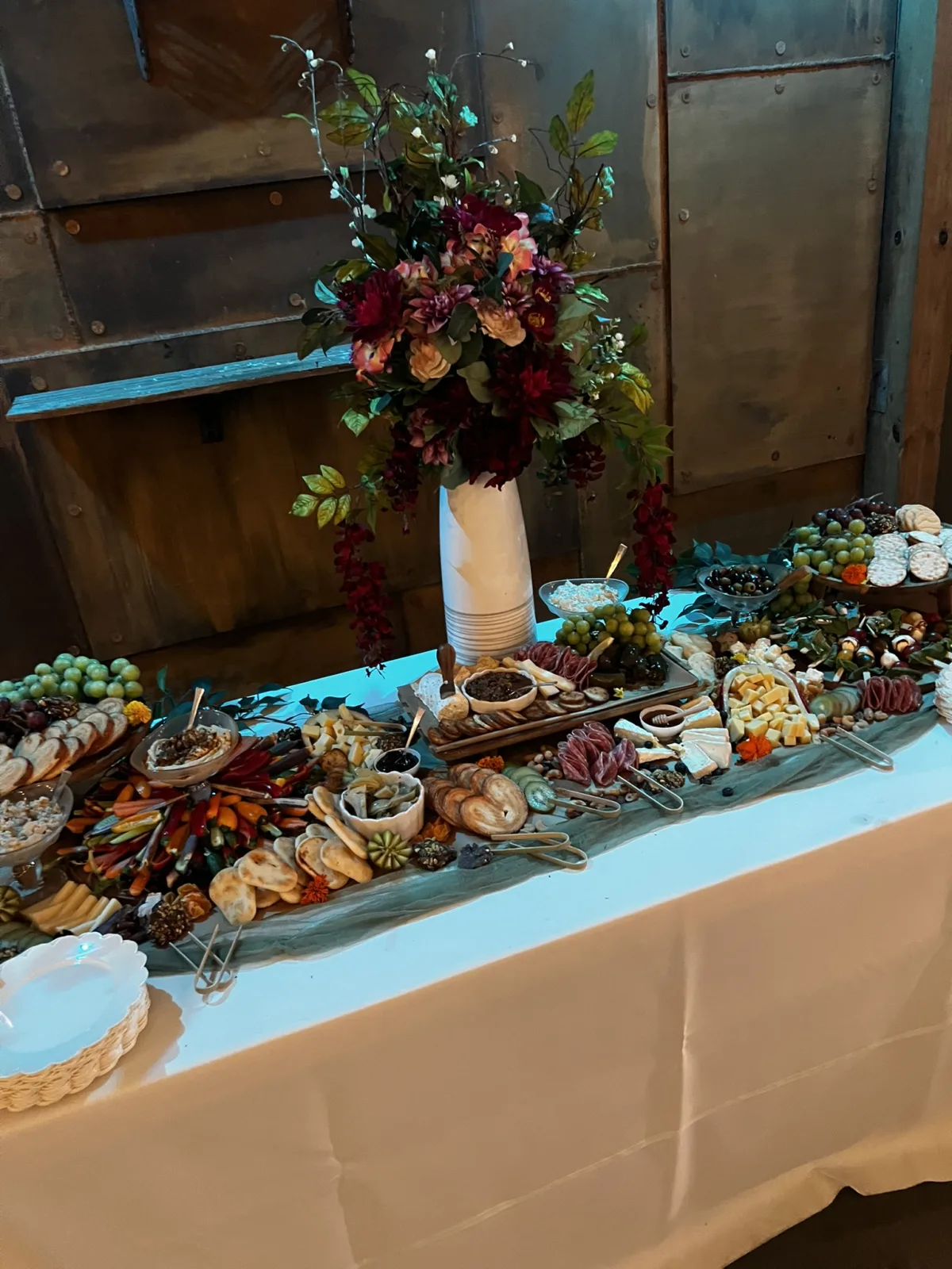 Luxury grazing table featuring artisan meats, cheeses, fruit, breads and accompaniments for wedding guests.