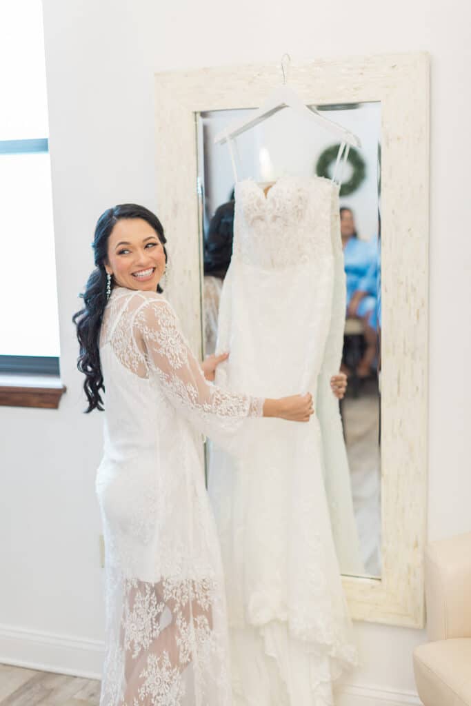 bride showing off her wedding dress, handing from a mirror, Orlando, FL
