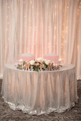 head table, pink uplighting, pink ribbons on the chairs, white flowers, Crowne Plaza Melbourne Oceanfront, Orlando, FL