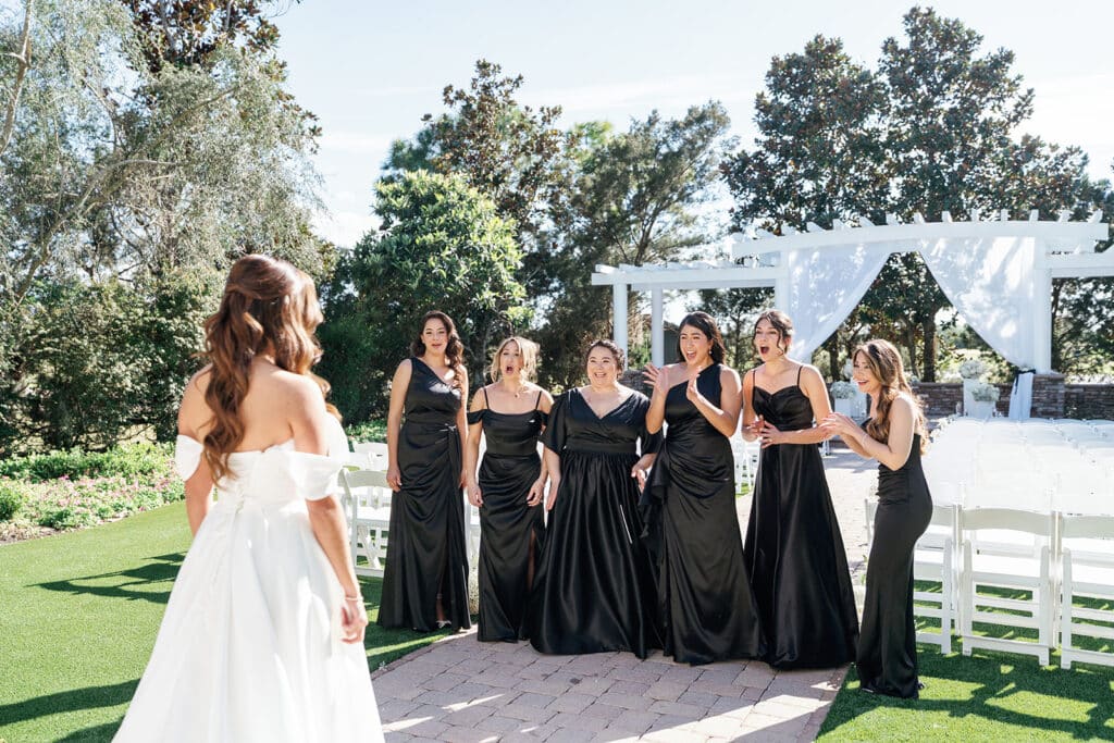 bride with her bridesmaids in black dresses, outdoors, wedding ceremony set up, Orlando, FL