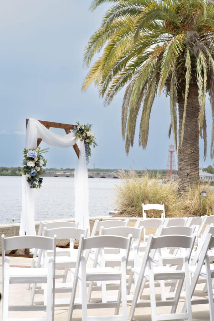wedding ceremony set up, outdoors, palm tree, blue sky, white chairs, The Waterfront Inn, Orlando, FL