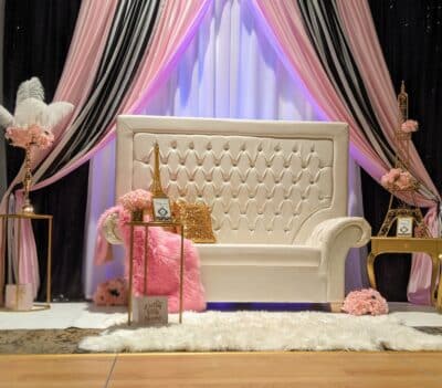 photo set up with a white sofa, pink blanket, gold metal Eiffel Tower decorations, white rug, pink, white and black curtains, Orlando, FL