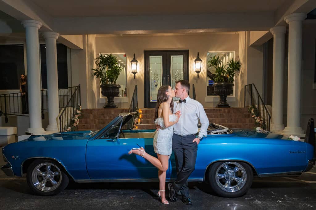 bride and groom kissing in front of a blue sports car, at the venue, Rockledge Country Club, Orlando, FL