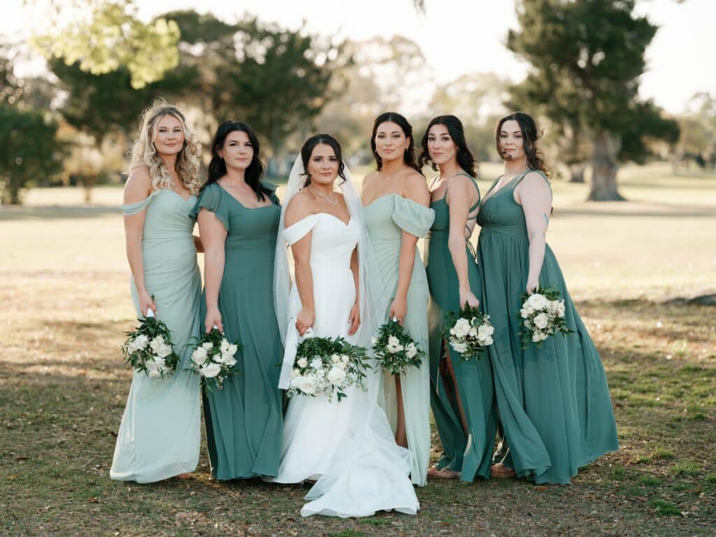 bride with her bridesmaids, shades of green dresses, outdoors, Orlando, FL