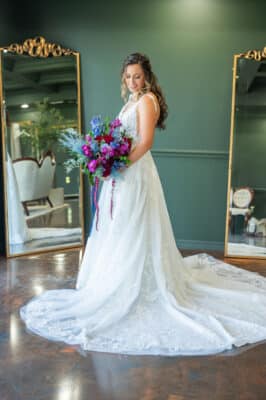 bride in her wedding gown, purple and blue flower bouquet, dress train spread out for display, Orlando, FL