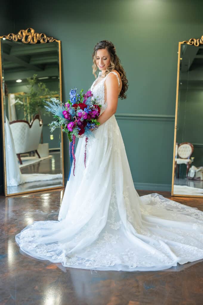 bride in her wedding gown, purple and blue flower bouquet, dress train spread out for display, Orlando, FL