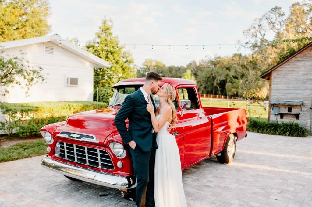 wedding couple kissing next to a red pick up truck, Moss Estates, Orlando, FL
