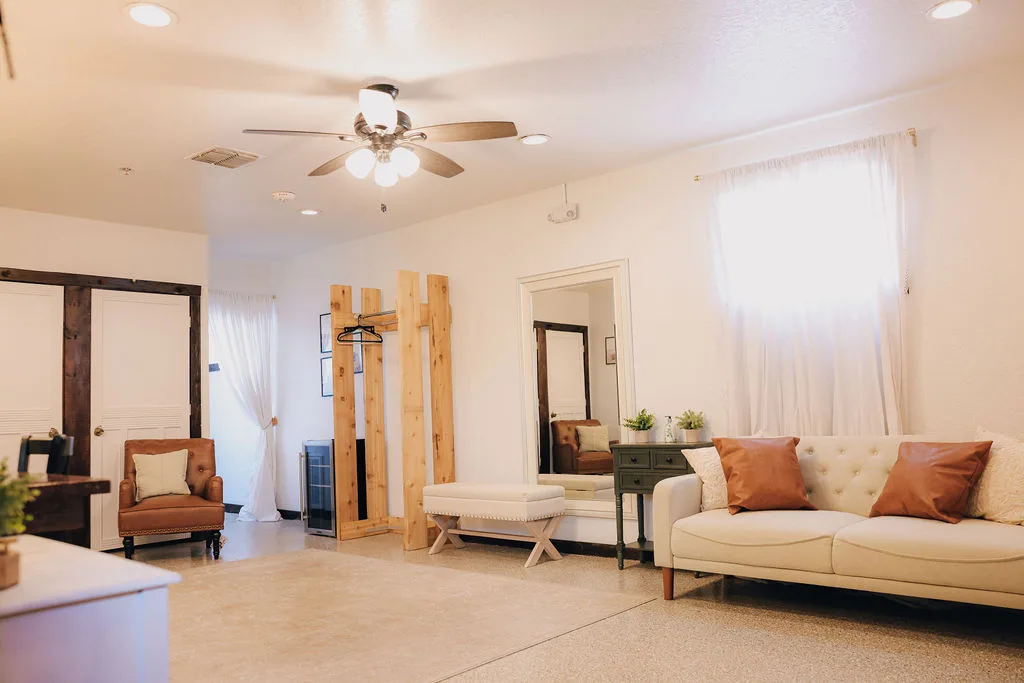 Spacious bridal suite at The Ranch at St. Cloud with lounge seating, natural light, mirror, and getting-ready area.