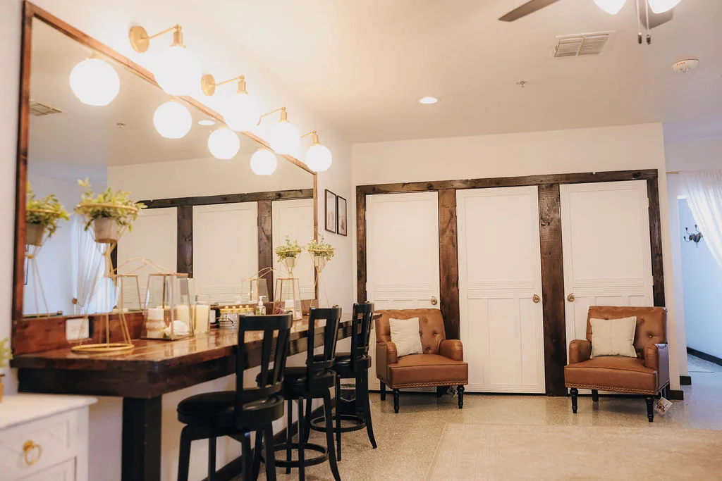 Bridal suite vanity with mirror lighting and seating at The Ranch at St. Cloud, ideal for wedding day hair and makeup.