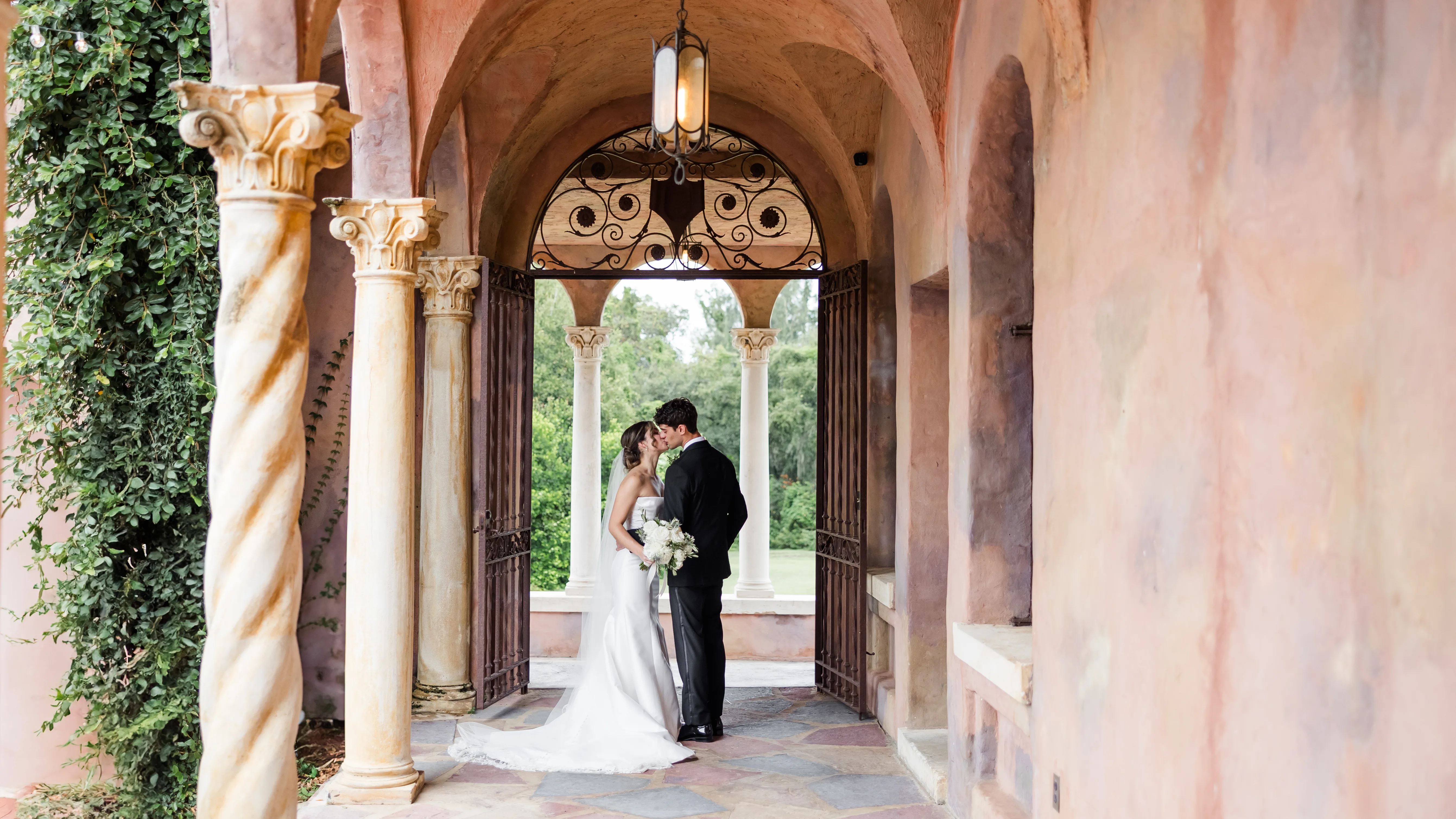 Blak Marie Photography Orlando Wedding Photographer Abigail William Wedding Highlights 33 edited - Wedding Venue Shopping Tips Every Newly Engaged Couple Should Know bride and groom standing under arched walkway at romantic wedding venue with elegant architecture, helpful for wedding venue shopping tips