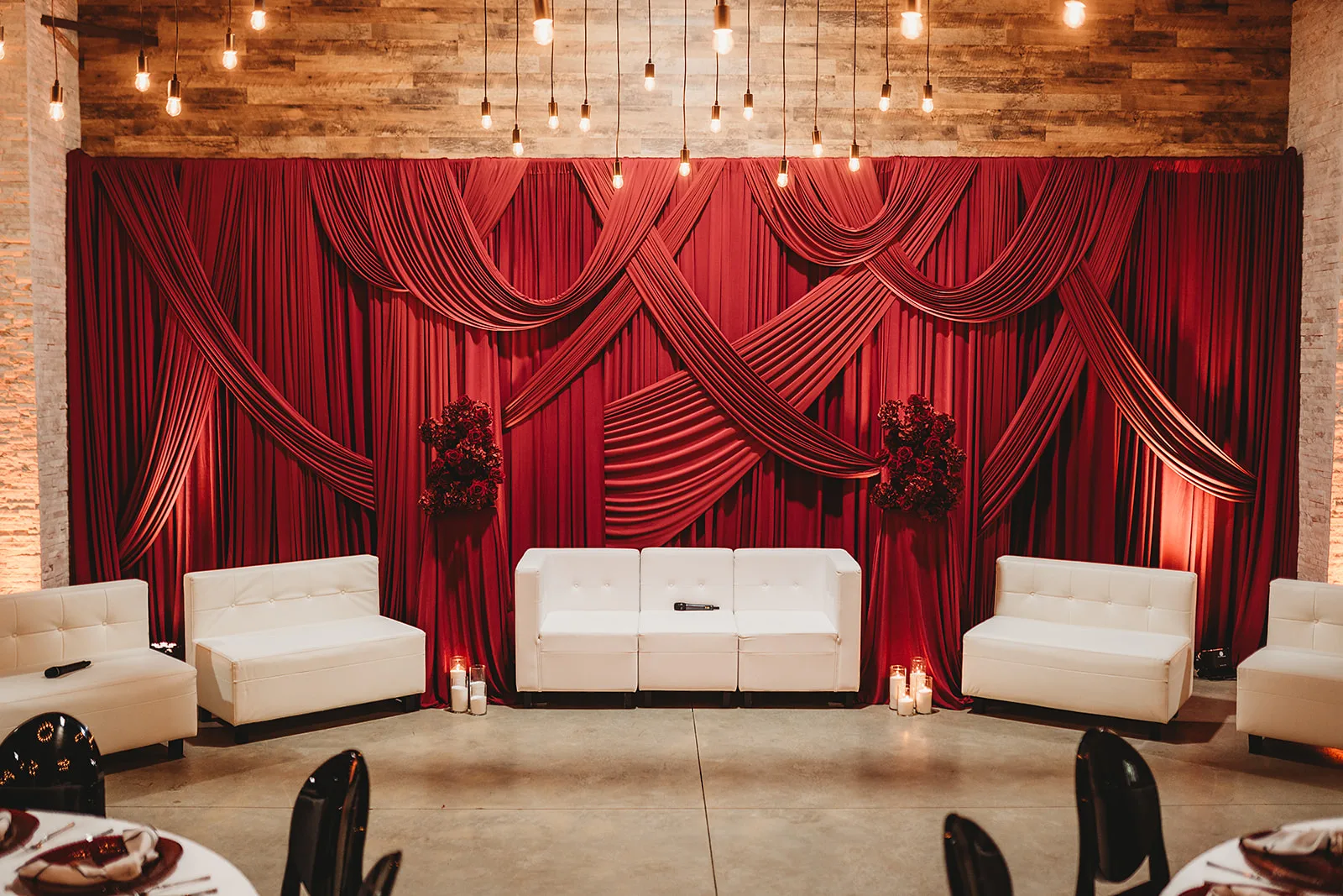 Gorgeous dark red backdrop draping with white couches for the Couples Tell All Wedding Pro Event stage 