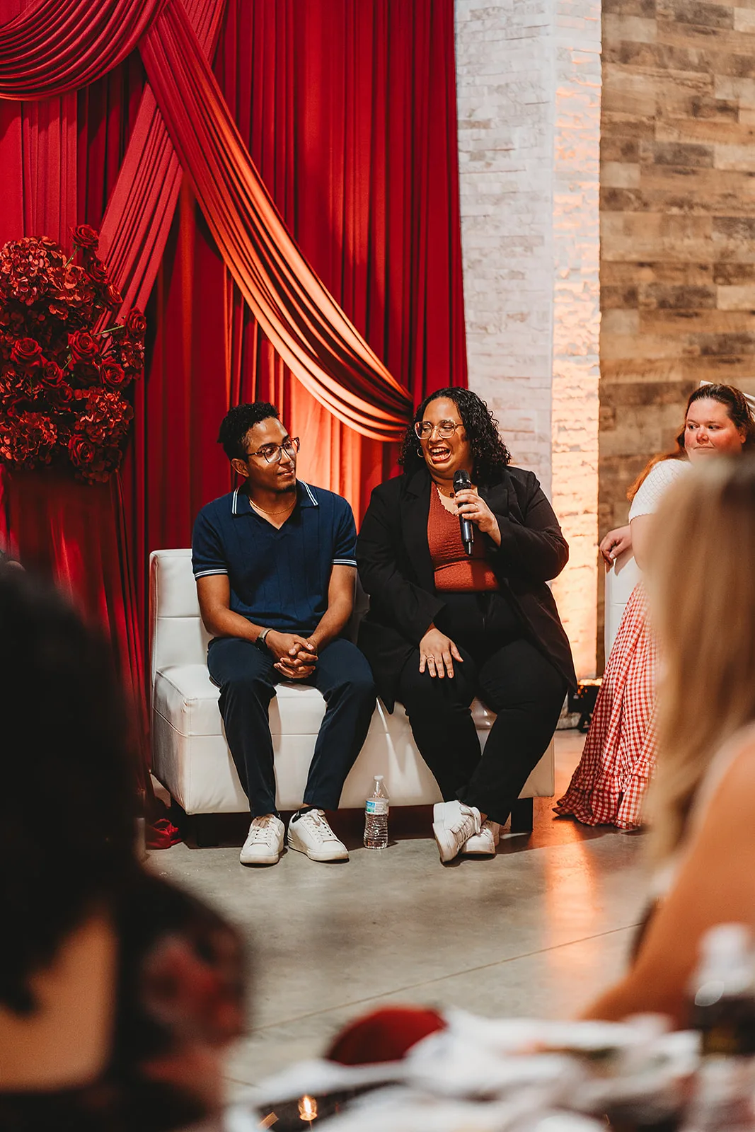 Couple with a mic on stage going over booking their vendor at the Couples Tell All Wedding Pro Event