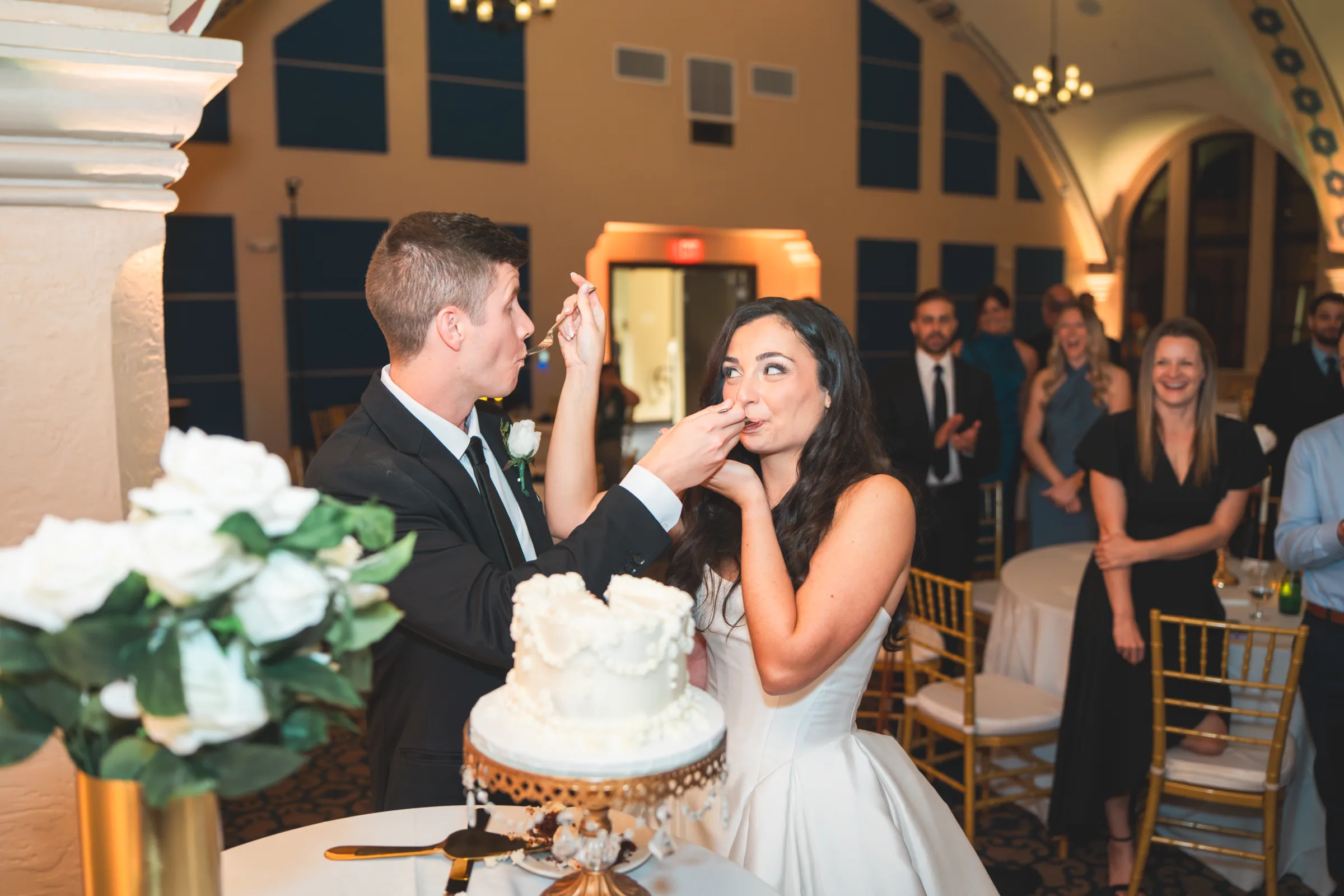 CodyKarinaWedding03.15.2026 1397 1 - European Inspired Wedding | Rollins College Bridge and groom cutting and feeding each other their wedding cake at european inspired wedding reception at Rollins College