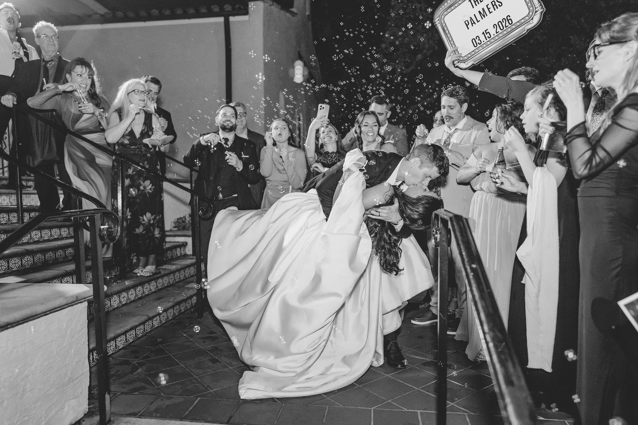 CodyKarinaWedding03.15.2026 1740 - European Inspired Wedding | Rollins College Bride and groom kissing at their grand exit sendoff, surrounded by bubbles being blow by the guests.