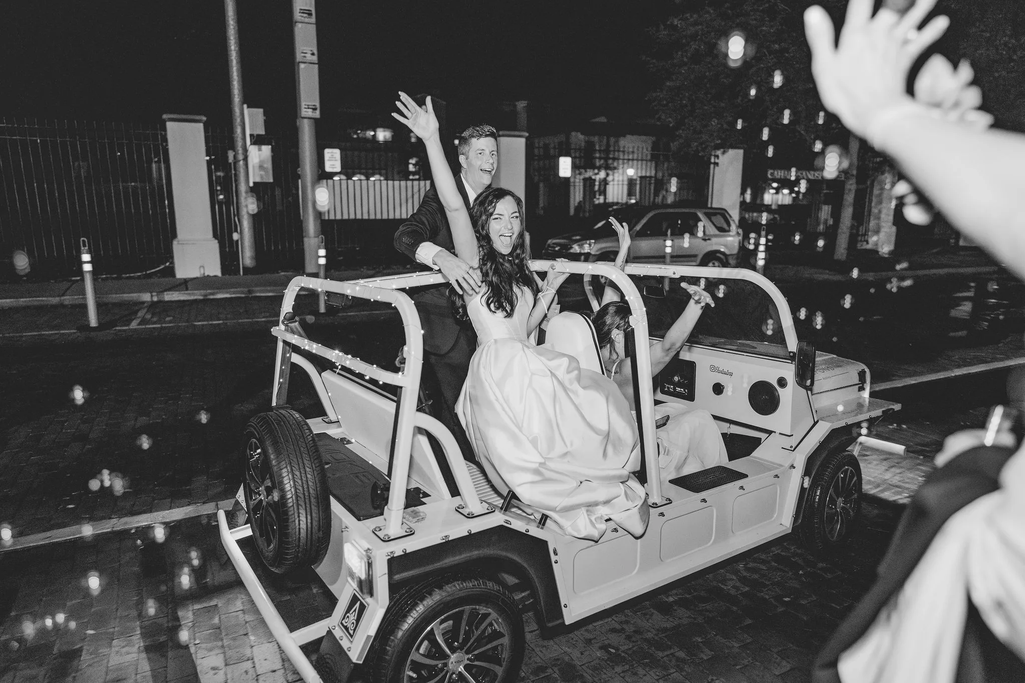CodyKarinaWedding03.15.2026 1776 - European Inspired Wedding | Rollins College Bride and groom celebrating their grand exit from their european inspired wedding at Rollins College in an open-air vehicle surrounded by bubbles