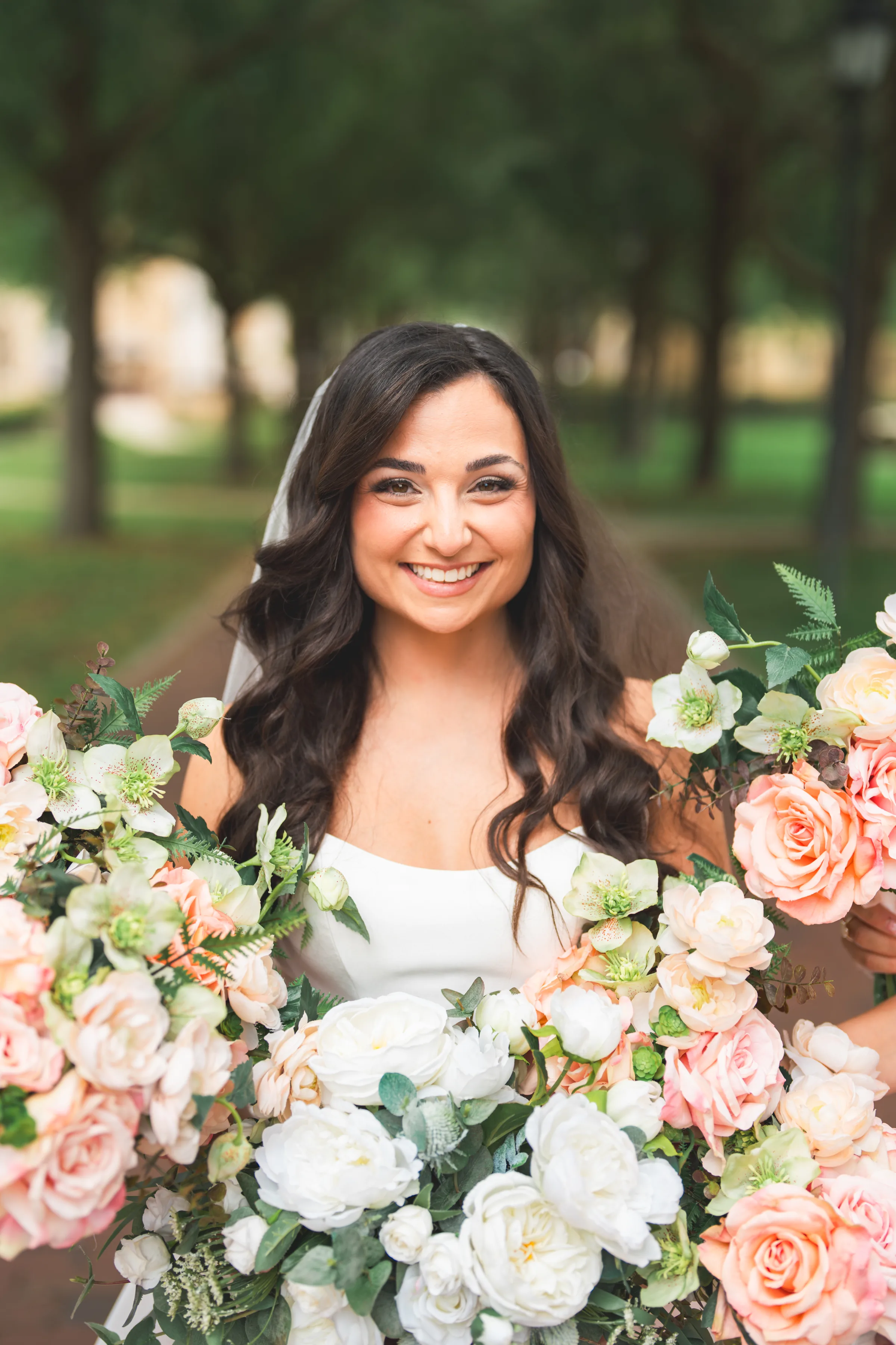 CodyKarinaWedding03.15.2026 196 - European Inspired Wedding | Rollins College Bride smiling and holding large blush pink and white floral bouquet at Rollins College european inspired wedding