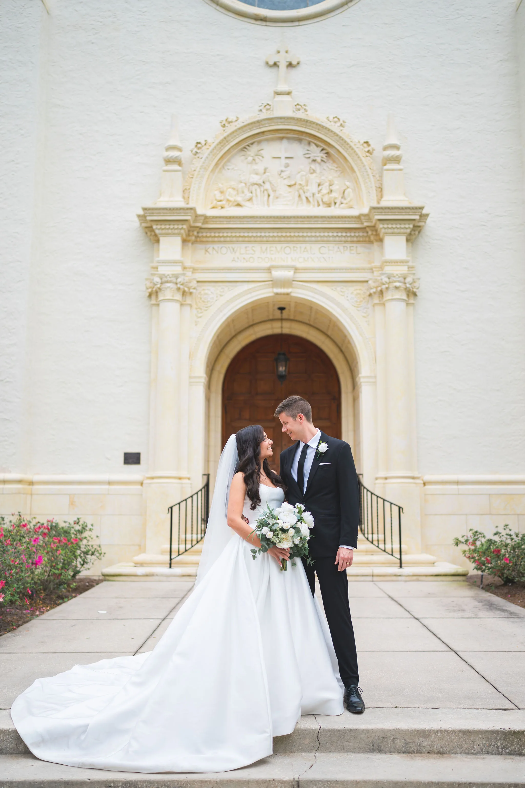 CodyKarinaWedding03.15.2026 683 - European Inspired Wedding | Rollins College Bride and groom standing outside Knowles Chapel wooden doors after their european inspired wedding ceremony