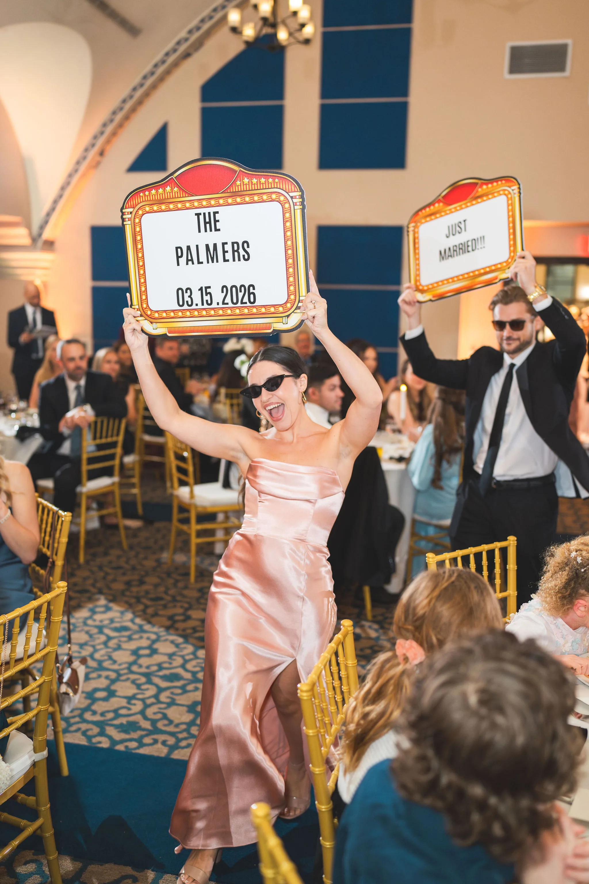 CodyKarinaWedding03.15.2026 937 - European Inspired Wedding | Rollins College Wedding party making their reception entrance holding a The Palmers marquee sign at Rollins College