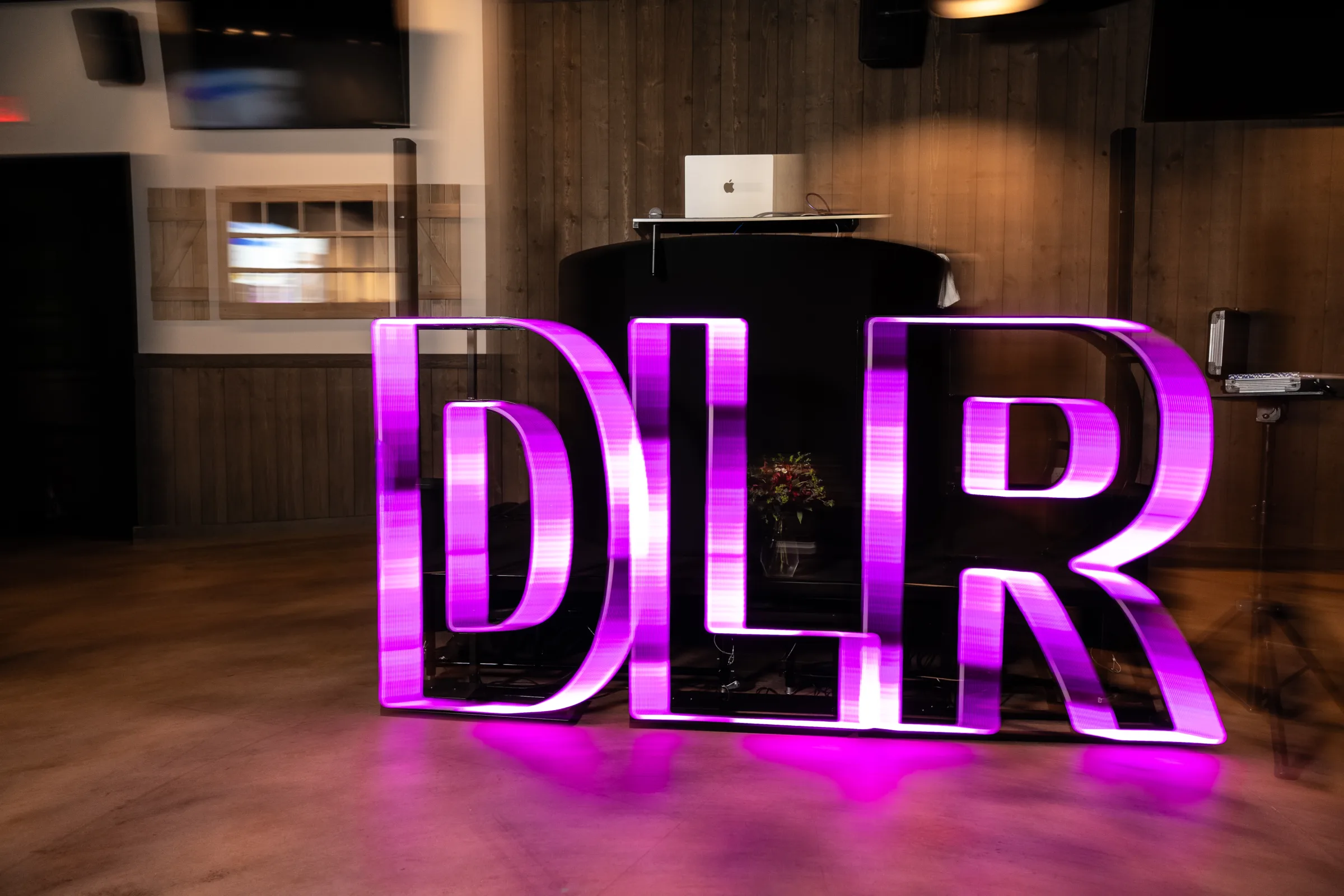 Sonacity Photography WVM DLR 37 - Inside Our Local Link Up Wedding Pro Event Image of neon signs refecting the letters D L R in neon pink for the local link up wedding pro event.