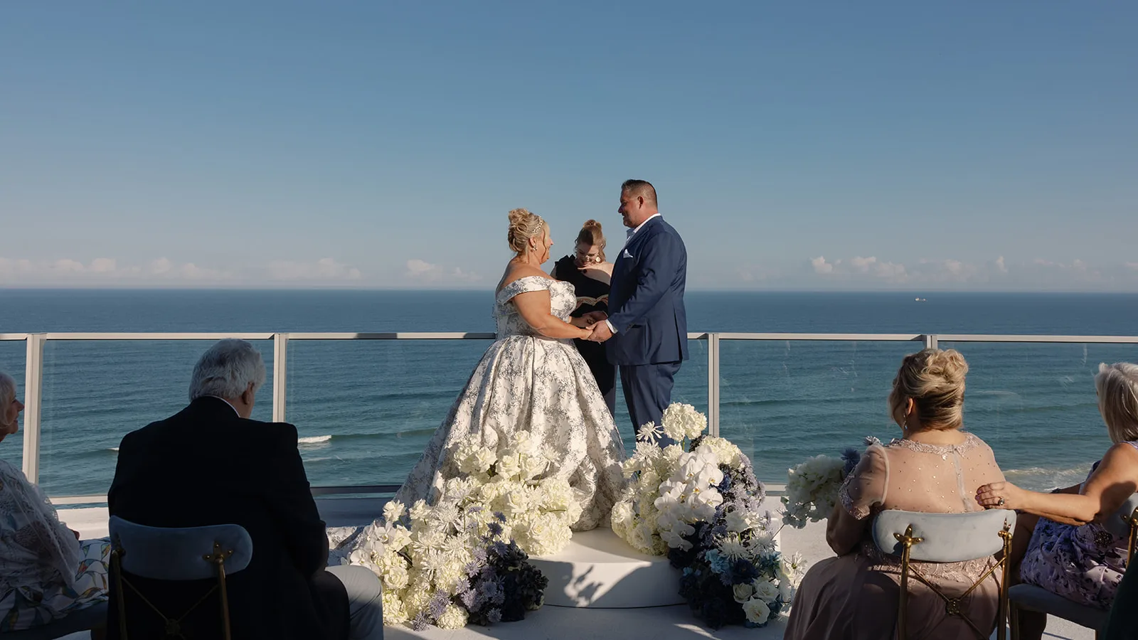BB Cer 139 edited - Romantic Blush and Blue Daytona Beach Wedding Bride and Groom at their wedding ceremony with the ocean in background