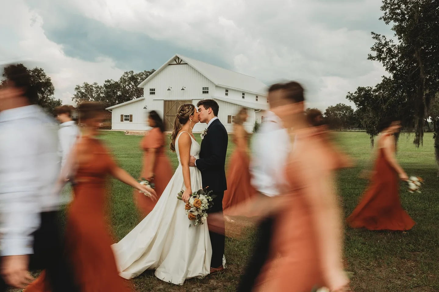 Couple kissing in front of barn wedding venue