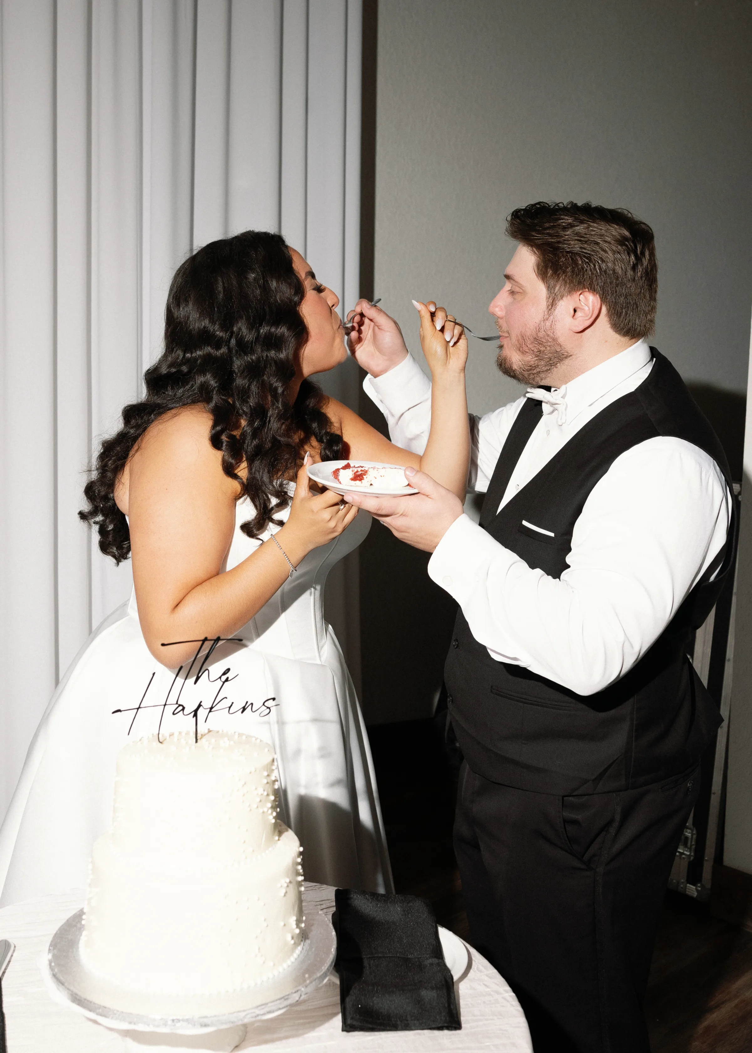 Bride and groom feeding each other wedding cake during reception at an Orlando Central Florida wedding venue, captured by The Harkins photography