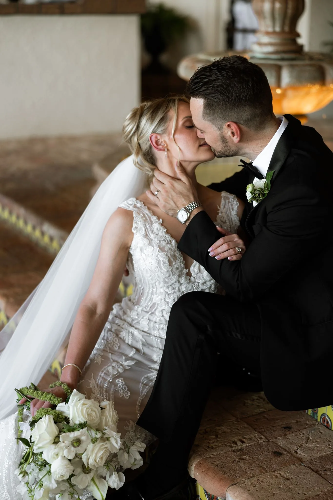 lilac ivory wedding bride groom kiss la hacienda - An Elegant Lilac and Ivory Wedding at La Hacienda on Snow Hill Bride and groom sharing a romantic kiss at La Hacienda on Snow Hill in Orlando, Florida, with the bride wearing an elegant lace wedding gown and holding a white floral bouquet for this lilac and ivory wedding celebration