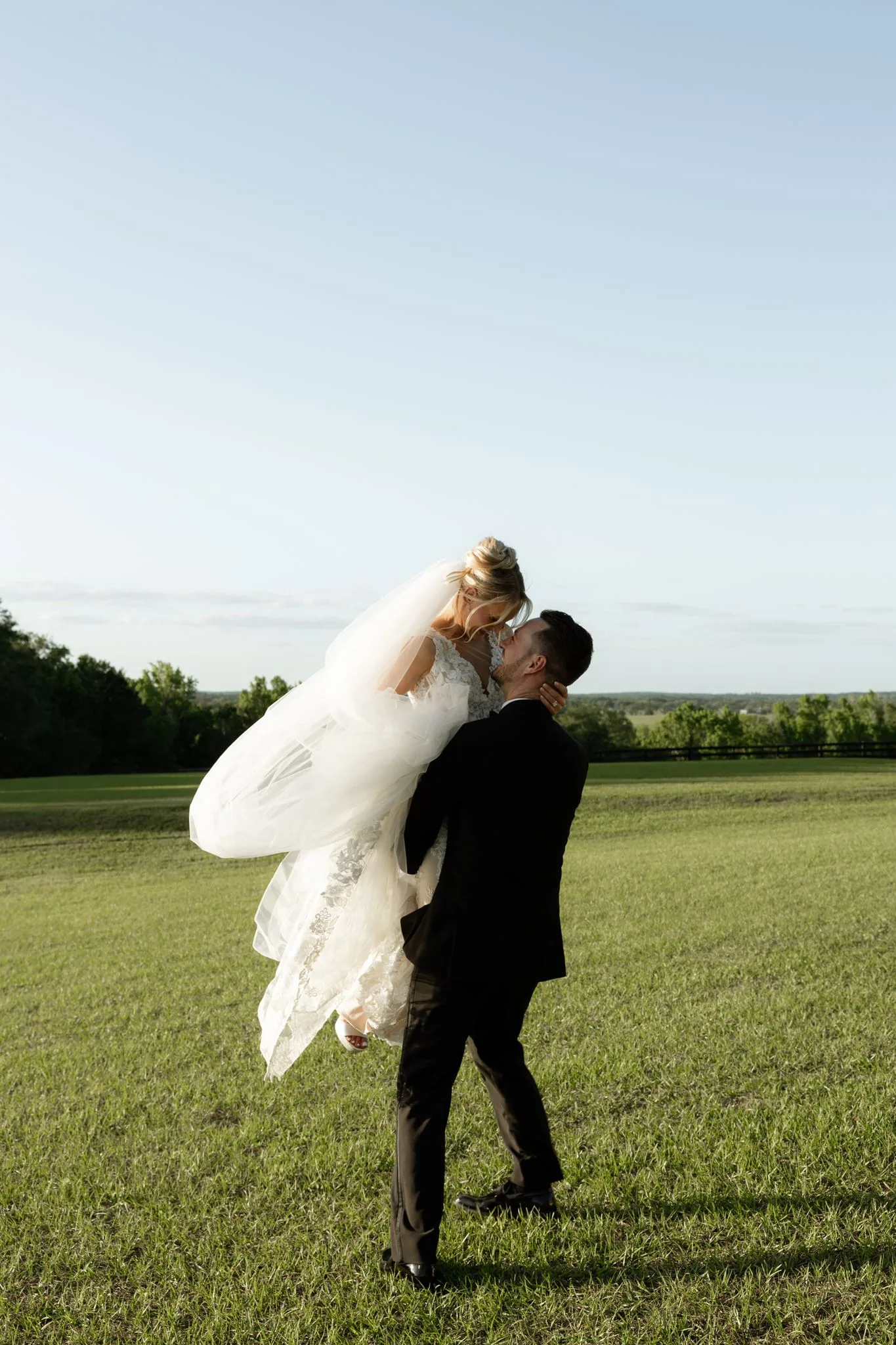 lilac ivory wedding bride groom lift la hacienda - An Elegant Lilac and Ivory Wedding at La Hacienda on Snow Hill Groom lifting bride in lace wedding gown for a romantic portrait at La Hacienda on Snow Hill, a lilac and ivory spring wedding in Central Florida