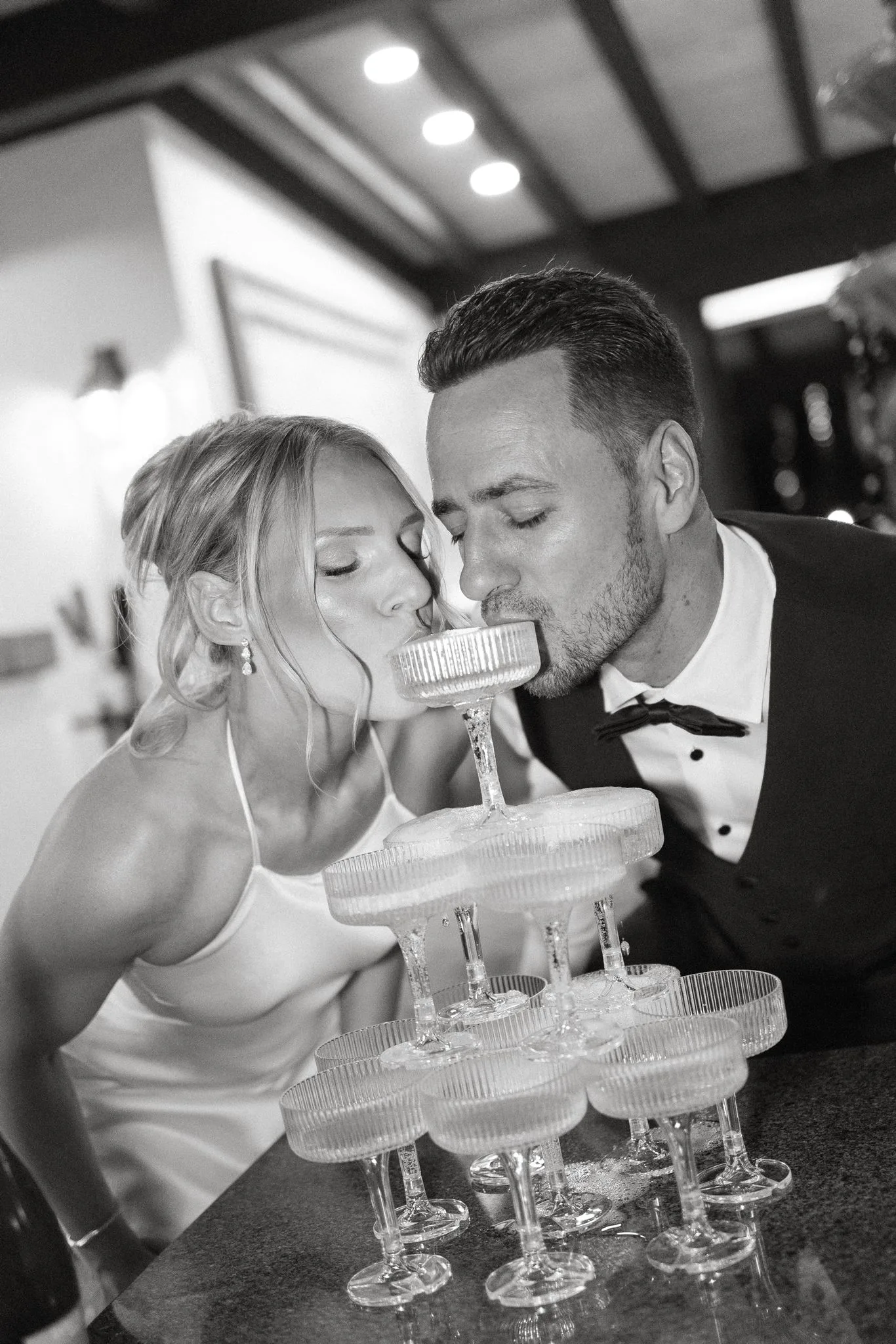 lilac ivory wedding champagne tower toast la hacienda - An Elegant Lilac and Ivory Wedding at La Hacienda on Snow Hill Bride and groom drinking from a champagne coupe tower together at their lilac and ivory wedding reception at La Hacienda on Snow Hill in Central Florida