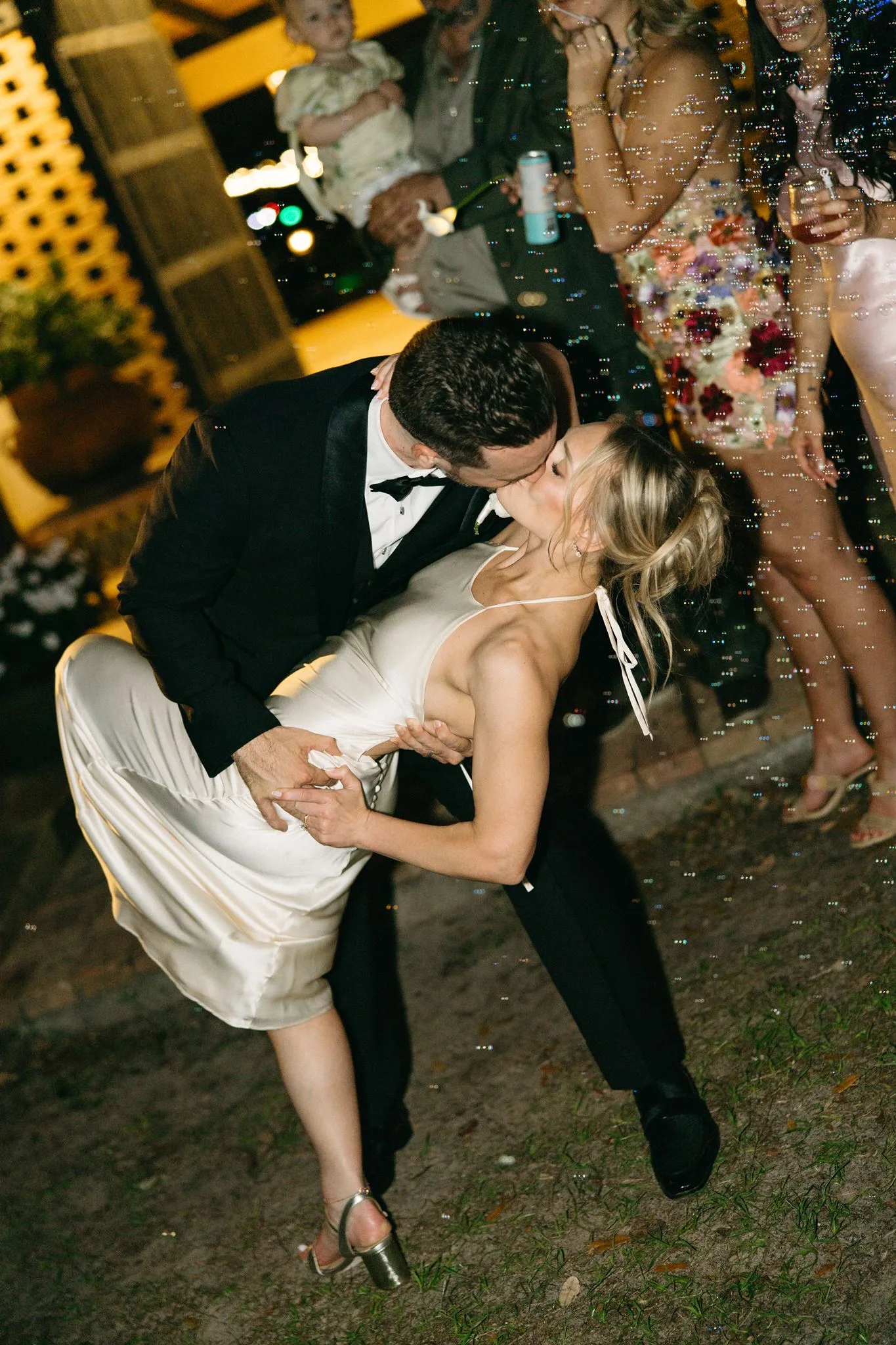 lilac ivory wedding first dance dip kiss la hacienda - An Elegant Lilac and Ivory Wedding at La Hacienda on Snow Hill Groom dips bride for a romantic kiss during first dance at La Hacienda on Snow Hill wedding reception in Orlando, Florida, surrounded by bubbles and guests