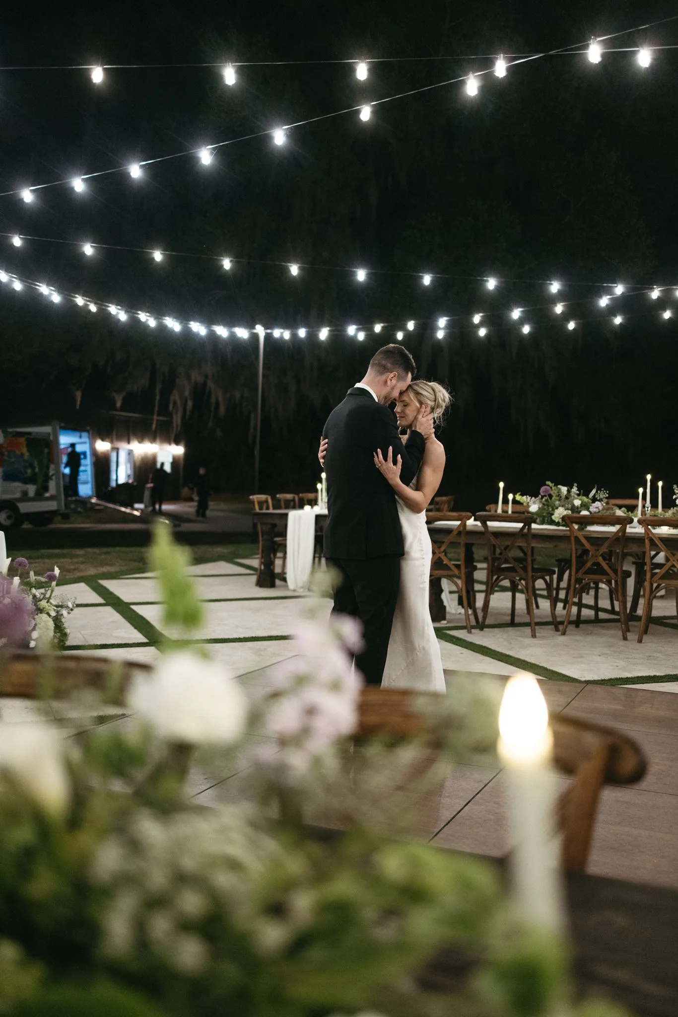 lilac ivory wedding first dance la hacienda snow hill 4 - An Elegant Lilac and Ivory Wedding at La Hacienda on Snow Hill Bride and groom share an intimate first dance under string lights at La Hacienda on Snow Hill in Orlando, surrounded by candlelit tablescapes and soft lilac and ivory floral arrangements