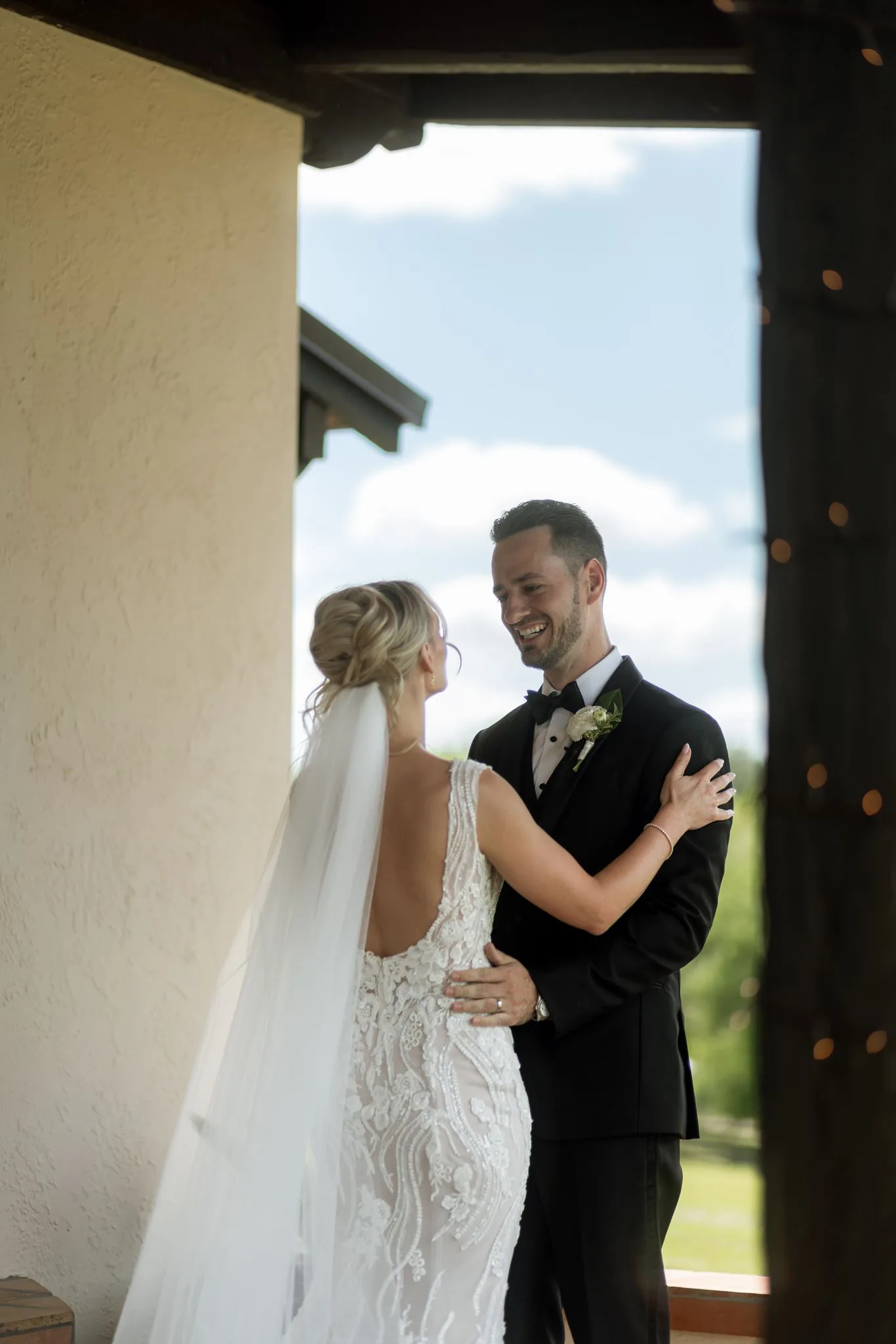lilac ivory wedding first look la hacienda snow hill 1 - An Elegant Lilac and Ivory Wedding at La Hacienda on Snow Hill Bride and groom share an emotional first look moment at La Hacienda on Snow Hill in Central Florida, with the bride in a backless lace gown and cathedral veil and the groom smiling in a black tuxedo during their lilac and ivory spring wedding