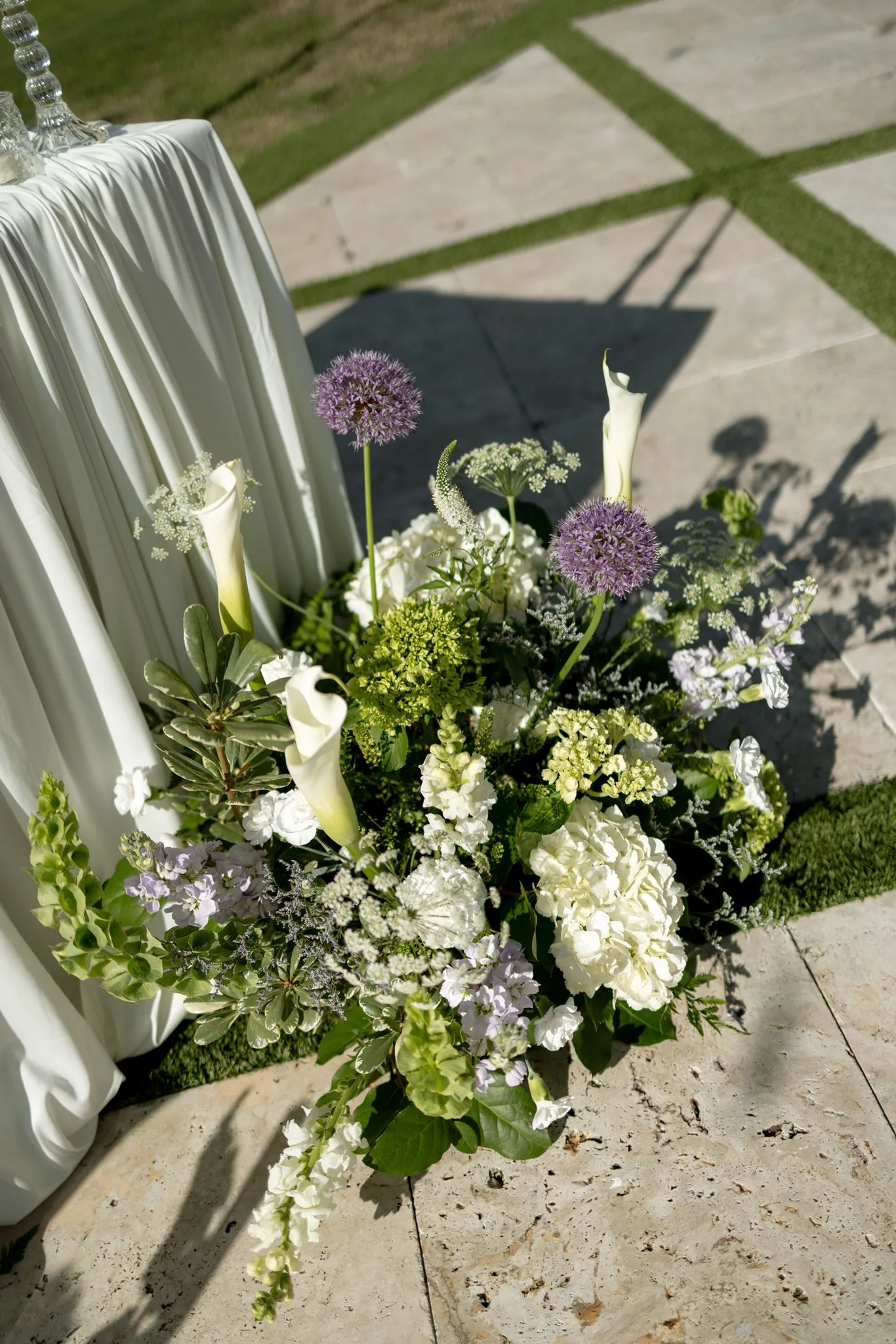 lilac ivory wedding florals la hacienda snow hill - An Elegant Lilac and Ivory Wedding at La Hacienda on Snow Hill Lush lilac allium and ivory calla lily wedding floor arrangement at La Hacienda on Snow Hill outdoor ceremony in Central Florida