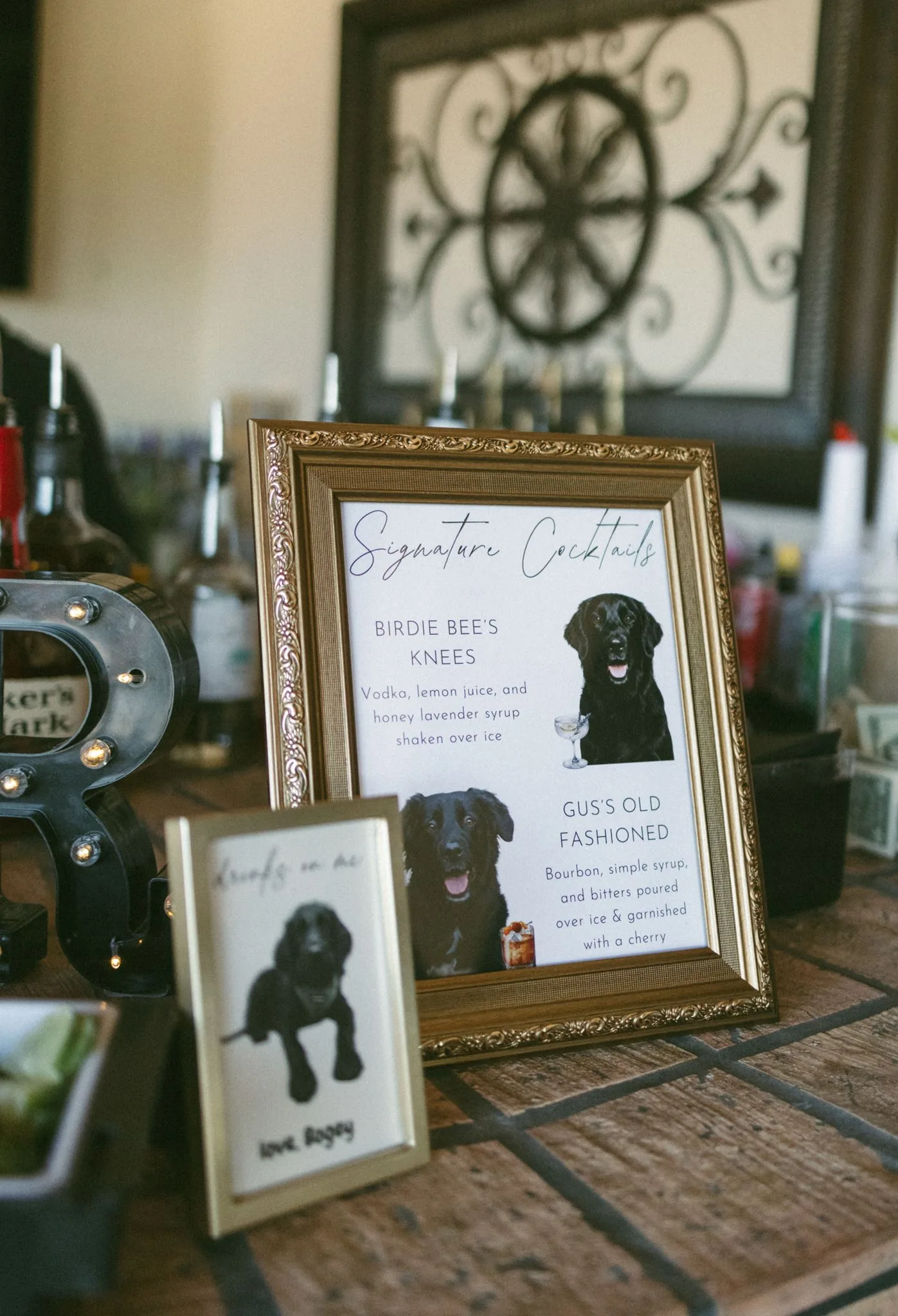 lilac ivory wedding signature cocktail sign la hacienda - An Elegant Lilac and Ivory Wedding at La Hacienda on Snow Hill Framed signature cocktail sign featuring illustrated black dogs named Birdie and Gus at a lilac and ivory wedding bar setup at La Hacienda on Snow Hill in Orlando, Florida