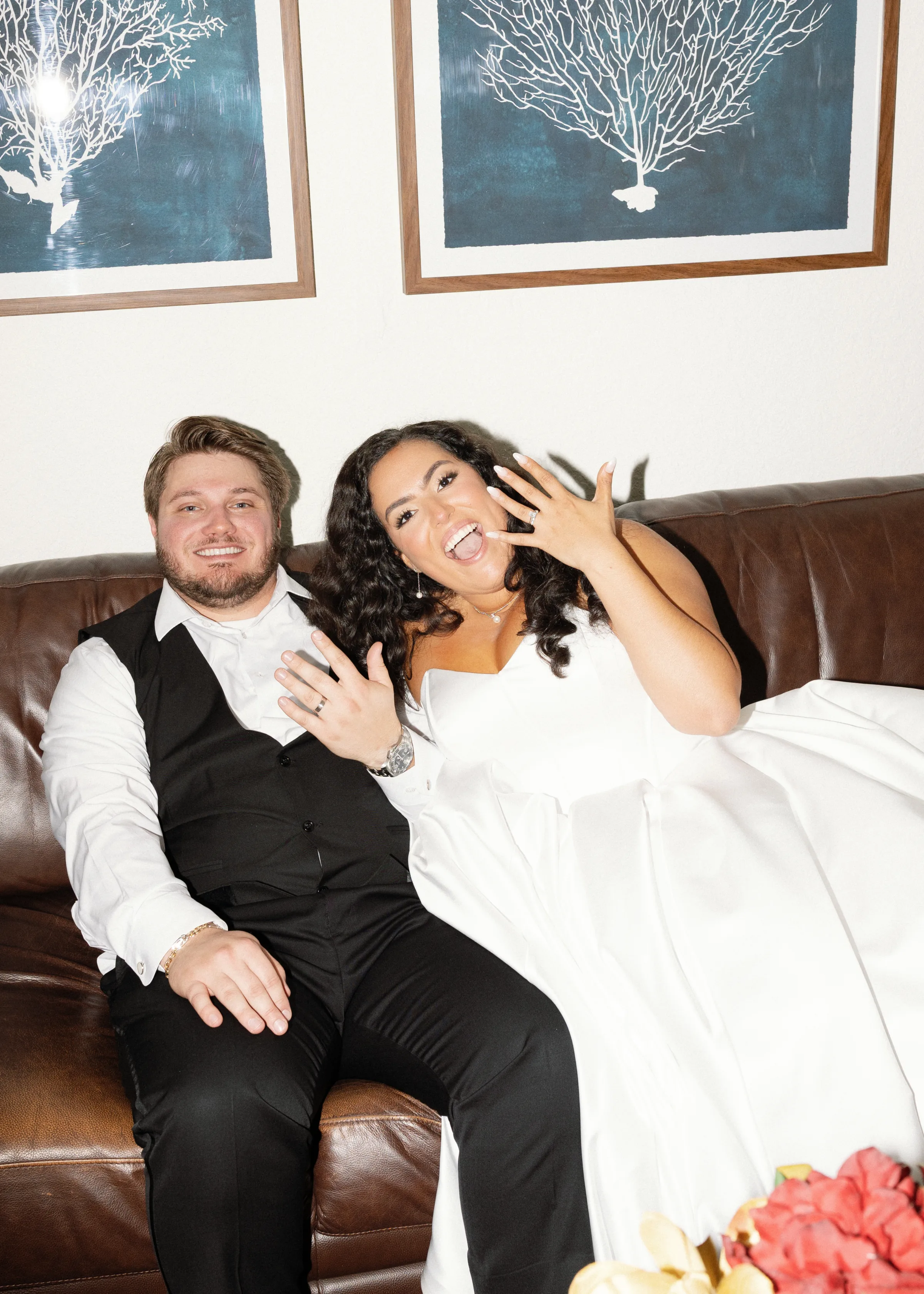 Bride and groom seated on a leather sofa showing off their wedding rings at an Orlando Central Florida wedding reception venue