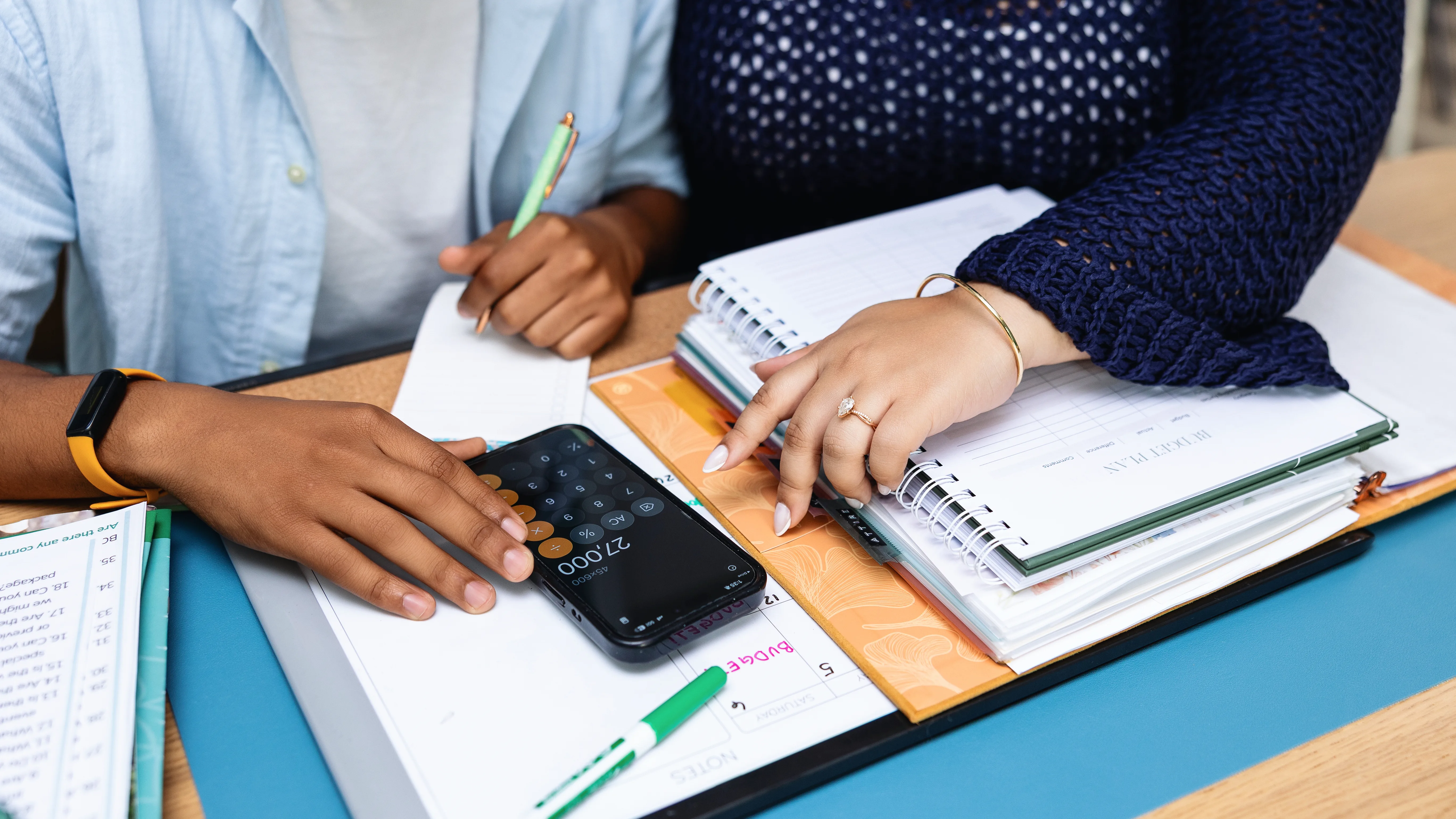 wedding budget planning couple reviewing finances together edited - Just Engaged? Now What? Newly engaged couple reviewing wedding budget plan with calculator and notebooks during financial planning session in Central Florida