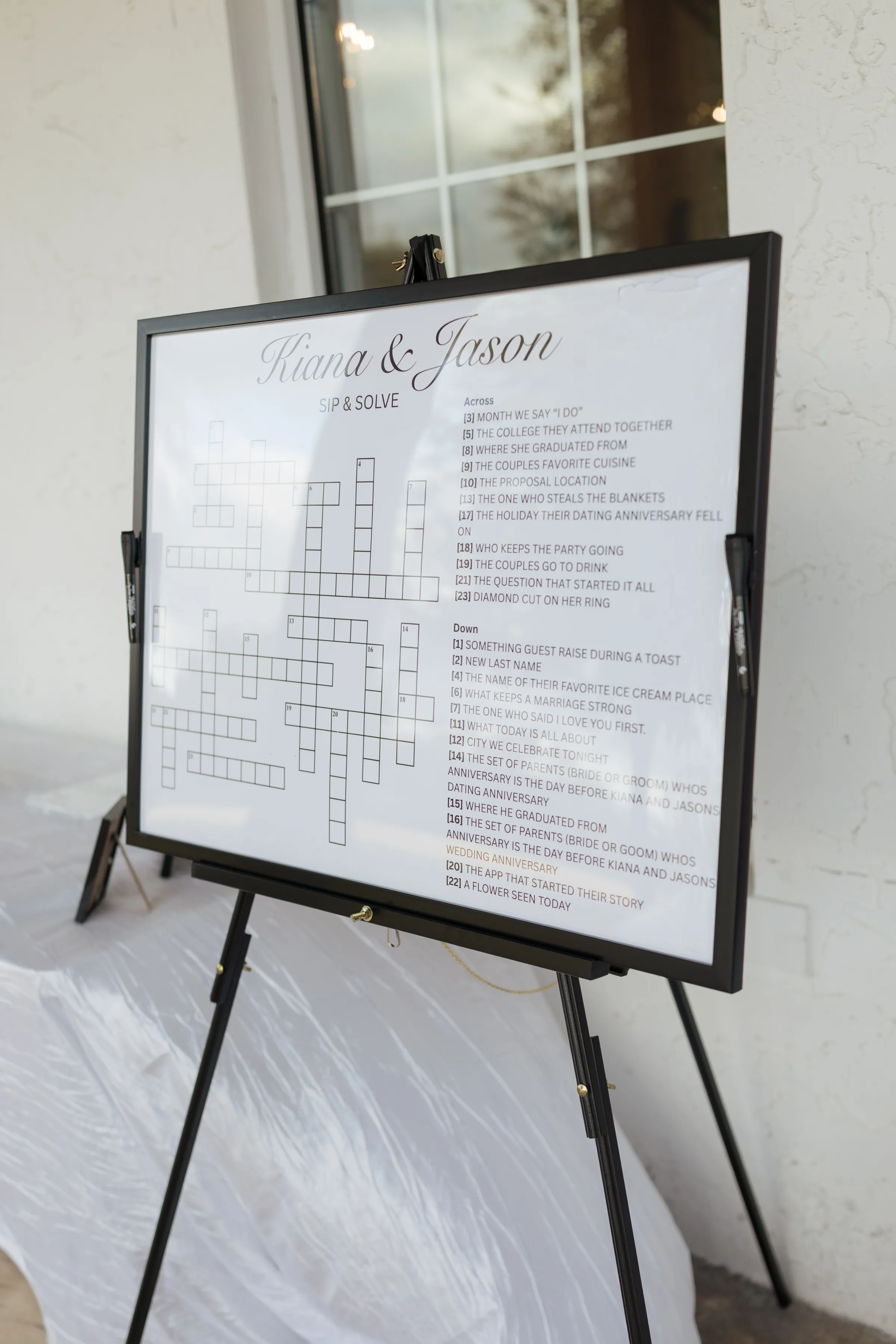 Custom couples crossword puzzle wedding sign titled Kiana and Jason Sip and Solve displayed on a black easel at an Orlando Central Florida wedding reception